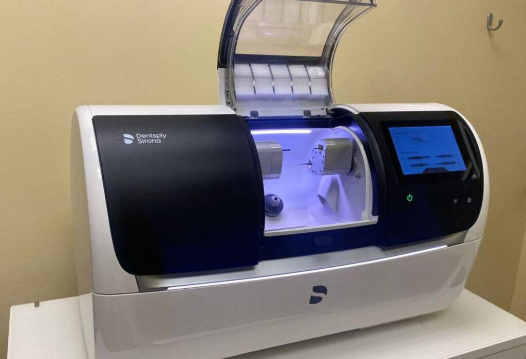 CEREC CAD/CAM system by Dentsply Sirona, featuring a sleek design and digital display, used for creating same-day dental crowns at The Village Dental in Miami, FL, enhancing patient comfort and efficiency.
