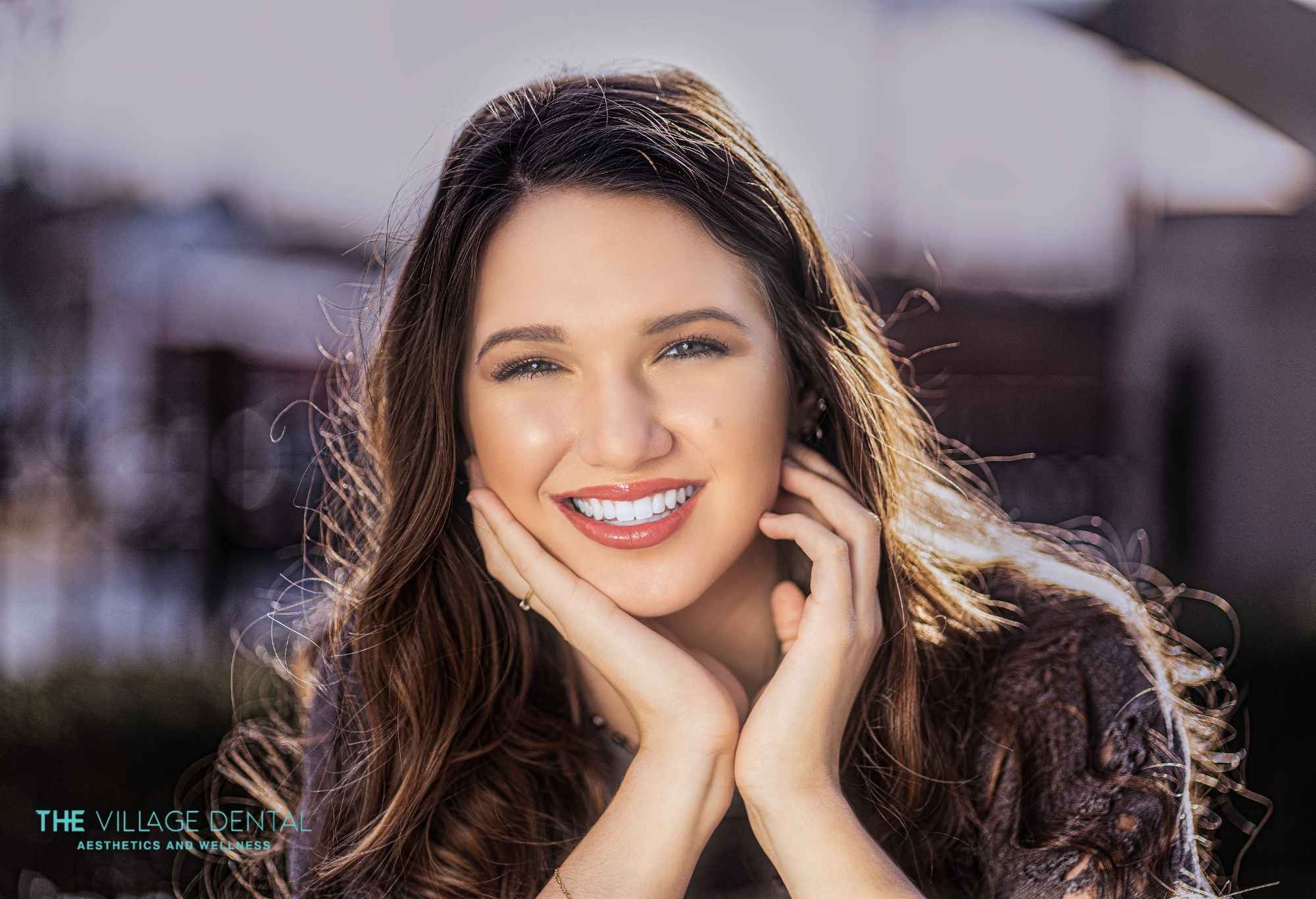 Smiling woman with long hair showcasing a radiant smile, representing the transformative effects of cosmetic dental services at The Village Dental in Pinecrest, FL.