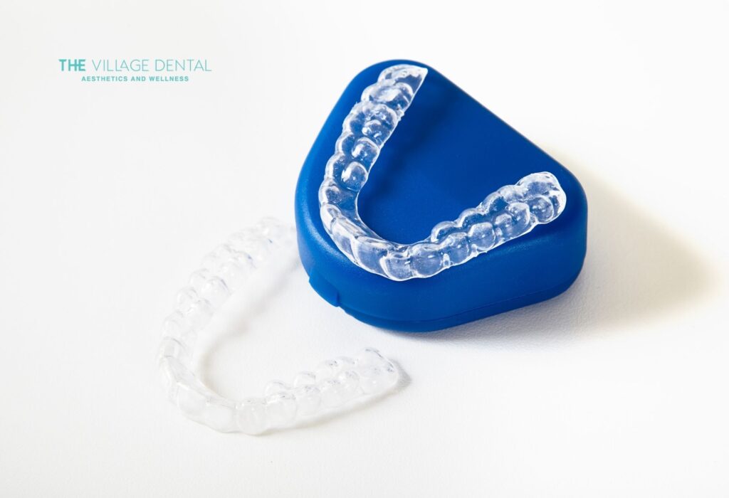 Custom take-home whitening trays from The Village Dental, designed for effective at-home teeth whitening, featuring a blue storage case and clear trays for comfortable wear and professional results.