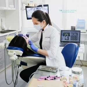 Dental professional performing an oral health examination at The Village Dental in Pinecrest, FL, with advanced technology and a focus on patient comfort.