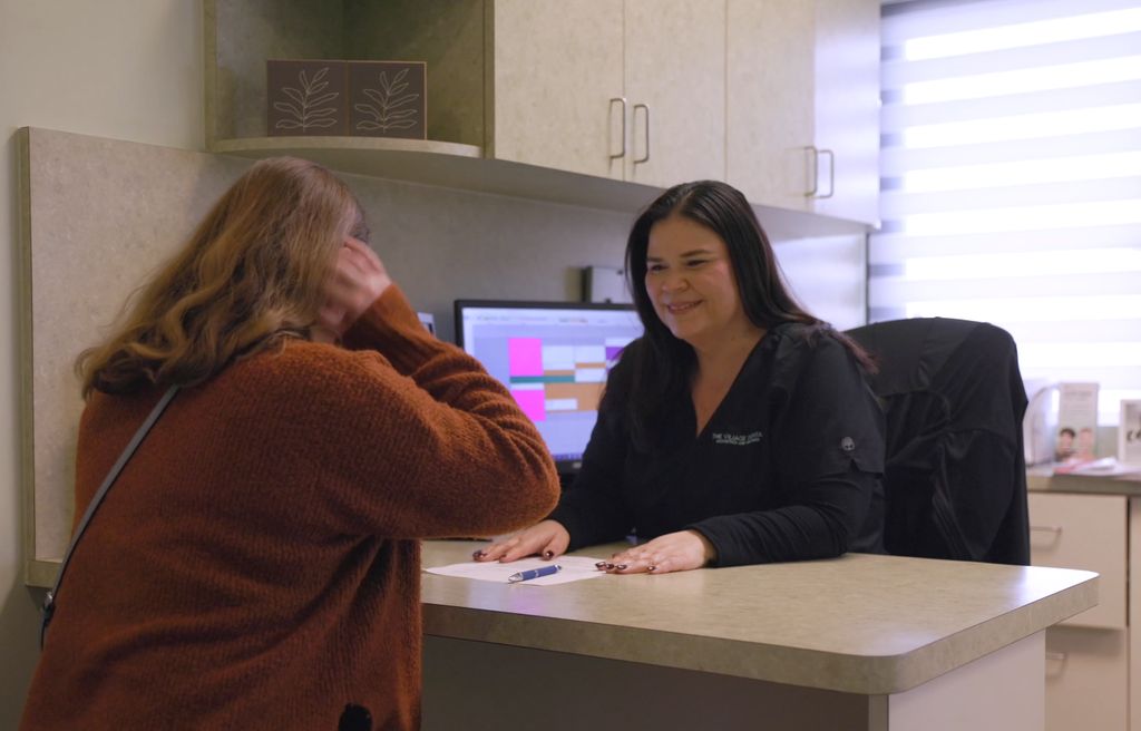 Friendly dental receptionist assisting a patient at The Village Dental in Pinecrest, FL, showcasing personalized care and a welcoming environment.